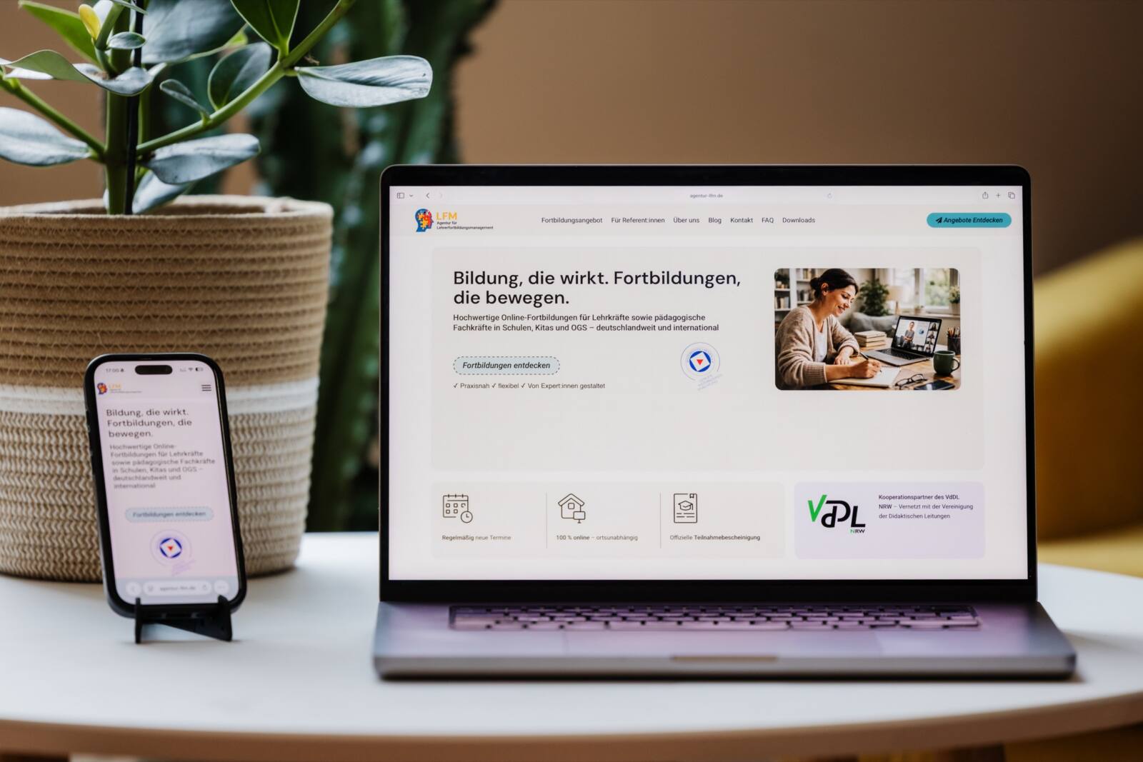 Macbook und Handy auf einem Couchtisch