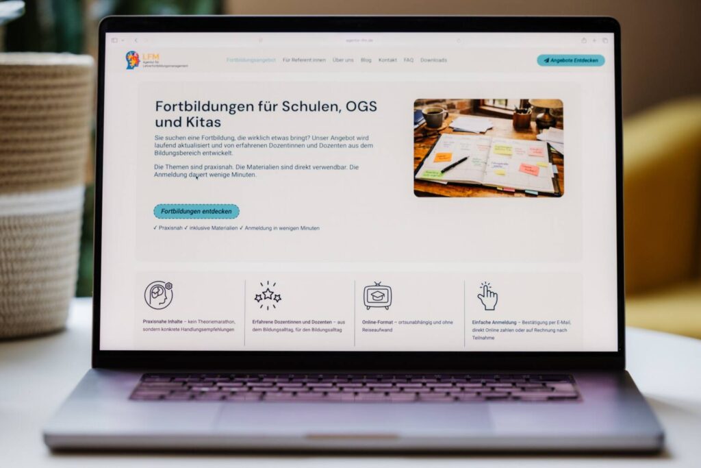 Macbook mit geöffneter Webseite auf einem Couchtisch