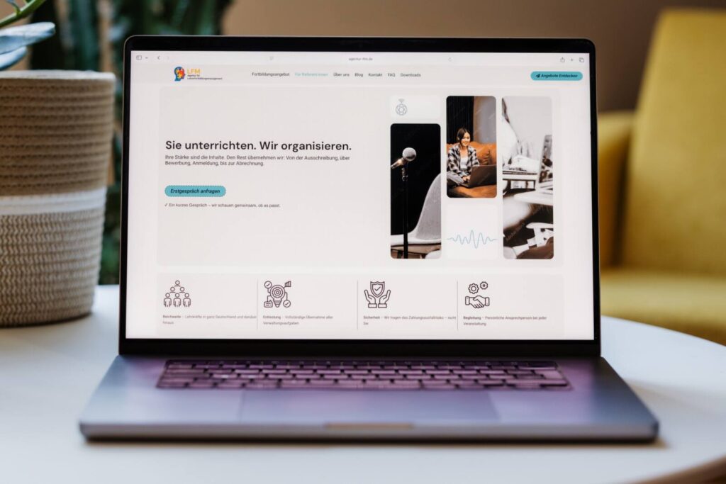 Macbook mit geöffneter Webseite auf einem Couchtisch